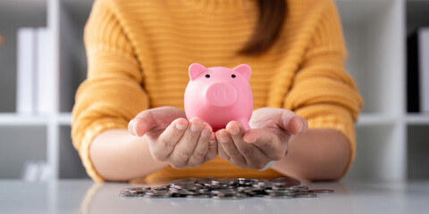 A woman is holding a piggy bank in his hands for a money or finance concept, support saving bank, Protect saving money concept - obrazy, fototapety, plakaty