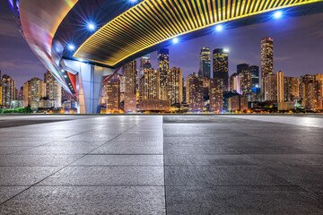 Empty square floor and bridge with modern city buildings at night in Chongqing