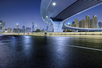 Asphalt highway road and bridge with modern city buildings at night in Chongqing