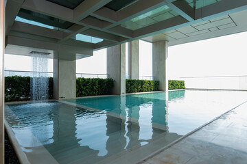 The swimming pool in the condo has a view of the tall buildings.