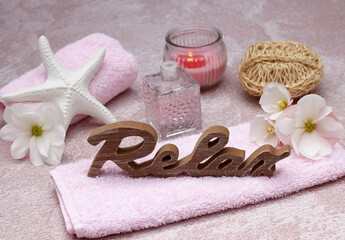 Spa Arrangement: Hautpflege- und Wellnessprodukte mit dem Deko-Schriftzug Relax.	