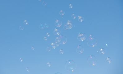 Floating soap bubbles on blue background