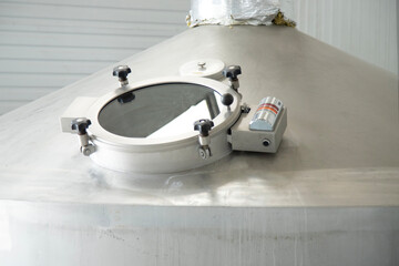Sight manhole of brewery equipment . Stainless steel  storage tank in a brewery factory