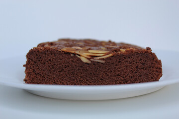 Brownies cake with almond topping, isolated on white background, side view