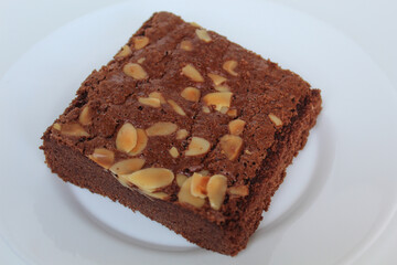 Brownies cake with almond topping, isolated on white background