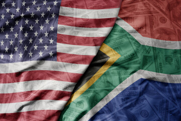 big waving colorful flag of united states of america and national flag of south africa on the...