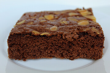 Brownies cake with almond topping, isolated on white background