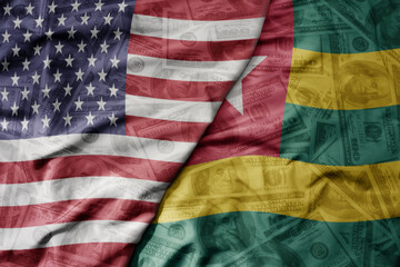 big waving colorful flag of united states of america and national flag of togo on the dollar money background. finance concept .