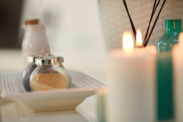 Candles, table and mineral salt at spa on for treatment, services and natural product for health at...