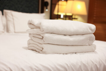 Stacked towels on bed in hotel room