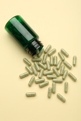 Vitamin pills and bottle on beige background, top view