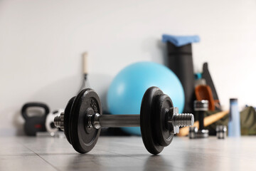 Dumbbell and other sports equipment indoors, closeup