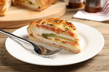 Piece of tasty homemade pie with filling served on wooden table
