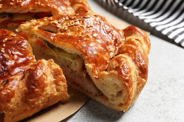 Cut delicious homemade pie on light grey table, closeup