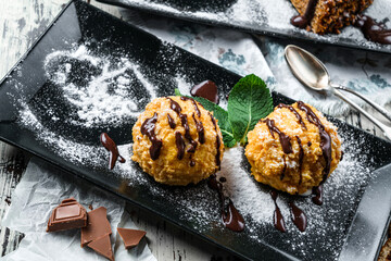 Crispy cakes with cream and chocolate on wooden background. Sweets, dessert and pastry, top view
