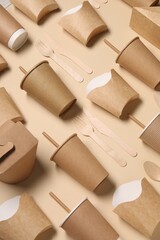 Eco friendly food packaging. Paper containers and wooden cutlery on beige background, above view
