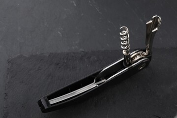 One corkscrew (sommelier knife) on grey textured table, closeup