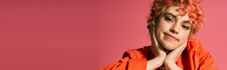 A vibrant woman dressed in an orange shirt up close.