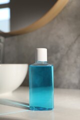 Bottle of mouthwash on light table in bathroom
