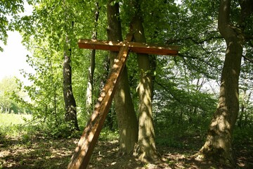 Fototapeta premium Wooden cross near trees in park outdoors