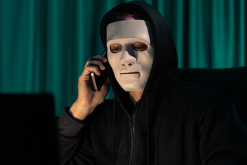 White criminal anonymous mask calling to IT owner to threaten ransom with big database, installing...