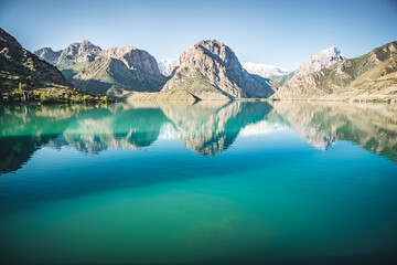 Panoramic view of blue Iskanderkul lake and rocky mountains in Tajikistan, the mountain range is...