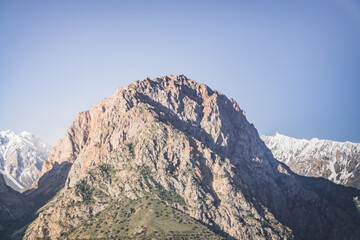 Rocky peaks of mountains and ridges with snow on an early sunny morning