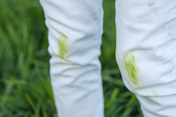 Close up dirty grass stains on white clothes. An unrecognizable person with green knees on a green...
