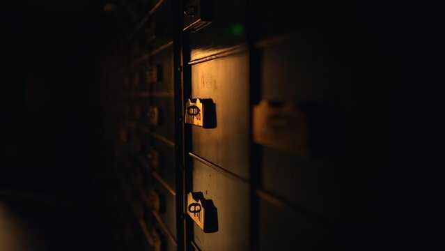 A row of lockers in a dark room illuminated by automotive lighting