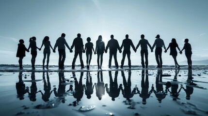 Business team silhouetted holding hands on a beach, embodying unity