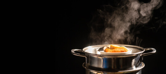 A boiling pot steams up as a chef cooking steam food in steam pot in a restaurant.	
