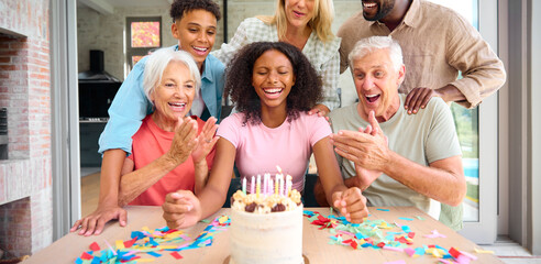 Three Generation Family Indoors At Home Celebrating Teenage Daughter's Birthday With Party And Cake