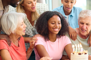 Three Generation Family Indoors At Home Celebrating Teenage Daughter's Birthday With Party And Cake