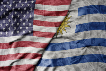 big waving colorful flag of united states of america and national flag of uruguay on the dollar money background. finance concept.