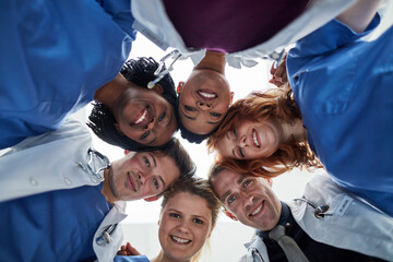 Portrait, teamwork or doctors in huddle with support in collaboration for healthcare mission. Hospital, happy people and low angle of medical nurses with group solidarity, motivation or community