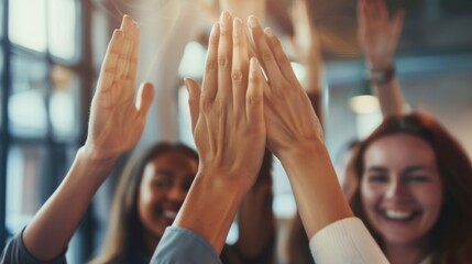 Close up a business team celebrating success with high fives and smiles in the office