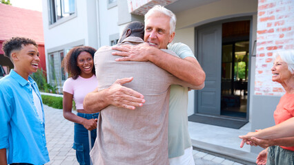 Grandparents Greeting Family With Teenage Children Coming To Visit