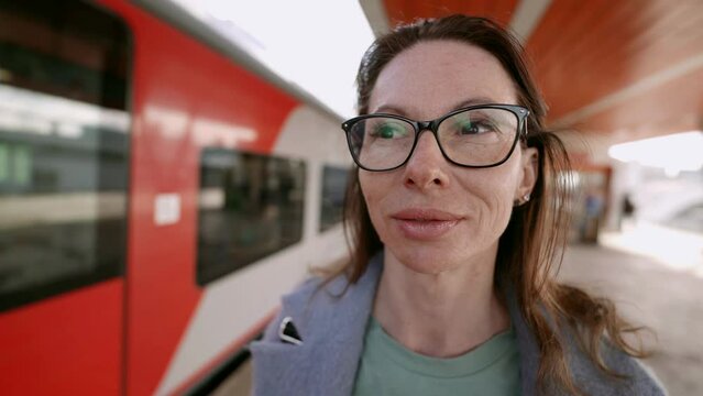 A video on public transport captures the moment when a pretty middle-aged woman, wearing glasses, enjoys the tranquility and peace of travel.