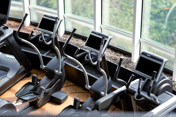 Several elliptical trainers in a modern gym. Modern gym Fitness center with equipment. Workouts,...