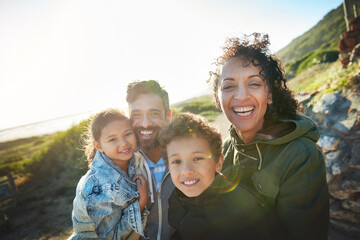 Holiday, mountain and outdoor portrait of family with smile, nature and bonding together on travel adventure. Mom, dad and children on summer vacation with hiking, happy face and sunshine on hill