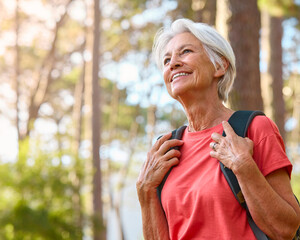 Fototapeta premium Active Senior Woman On Outdoor Hike In Countryside With Backpack