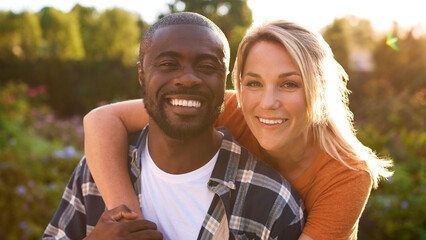 Portrait Of Loving Couple Hugging Outdoors In Countryside Together With Lens Flare
