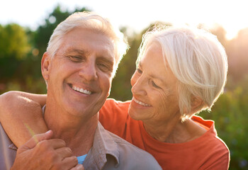 Portrait Of Loving Senior Couple On Hugging Outdoors In Countryside Together With Lens Flare