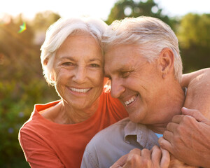 Portrait Of Loving Senior Couple On Hugging Outdoors In Countryside Together With Lens Flare