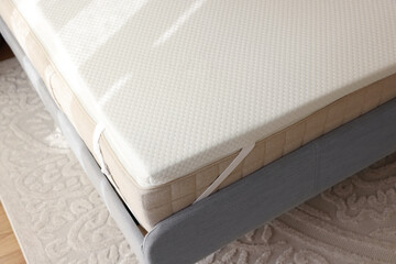 White memory foam mattress topper on grey bed