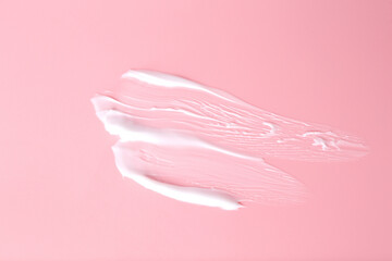 Sample of body care cream on pink background, top view