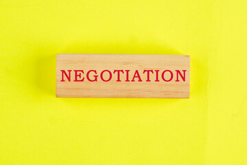Negotiation word on wooden blocks on a yellow background. Business concept