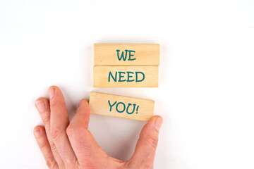 We Need You Message Concept on wooden blocks made up by human hand on a white background