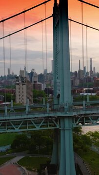 Cars driving fast by the bridge. Drone footage of Triborough Bridge against the metropolis of New York. Vertical video