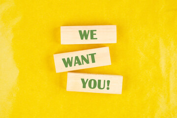 We want you on wooden blocks on a yellow background
